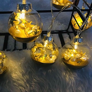 LED lyskæde med hvide perler og gule stjerner i kugle